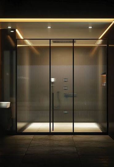 Reeded glass shower enclosure with warm lighting